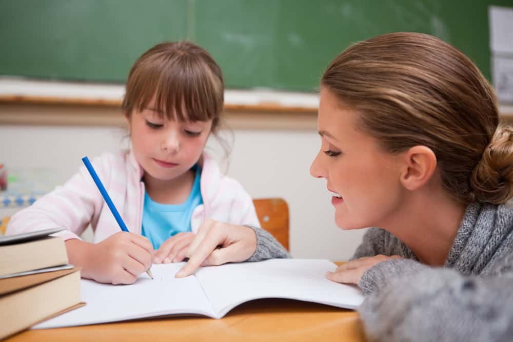 How To Start A Tutoring Business, tutor helping young student with homework