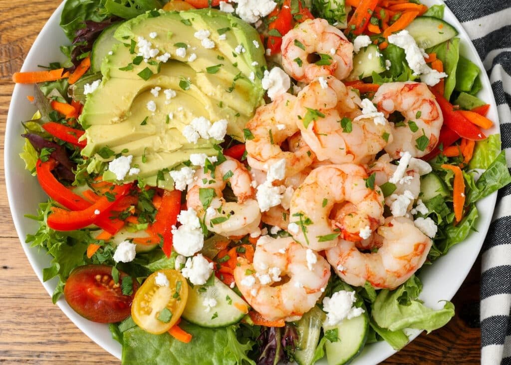 salad with avocado and shrimp on white platter 
