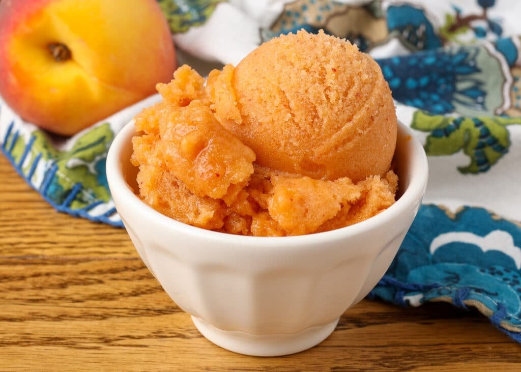 peach sorbet in white bowl on table