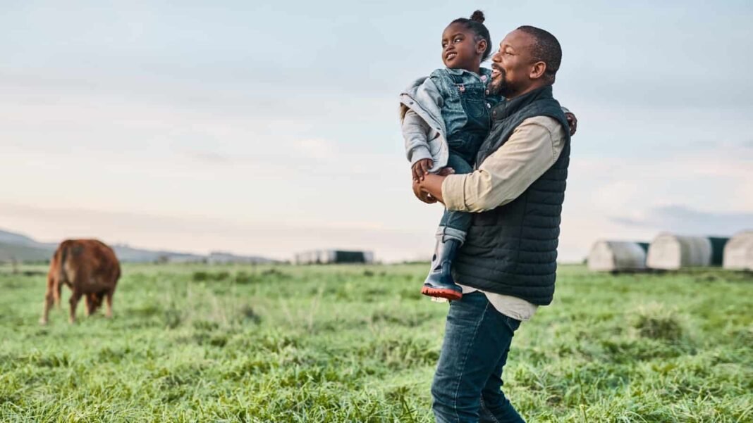 As stocks near all-time highs, we're looking to Warren Buffett Black father holding daughter in a field of cows