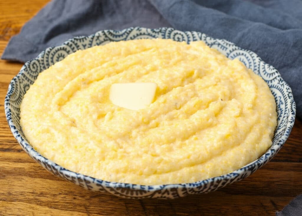 polenta in blue bowl topped with butter