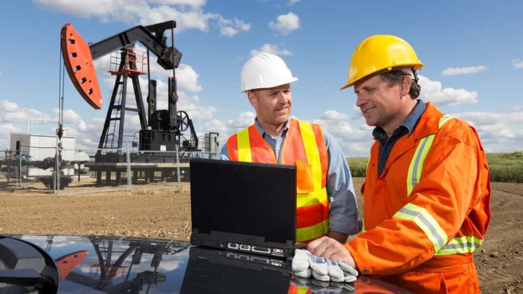 Experts predict next year's BP stock price trend Two white male workmen working on site at an oil rig