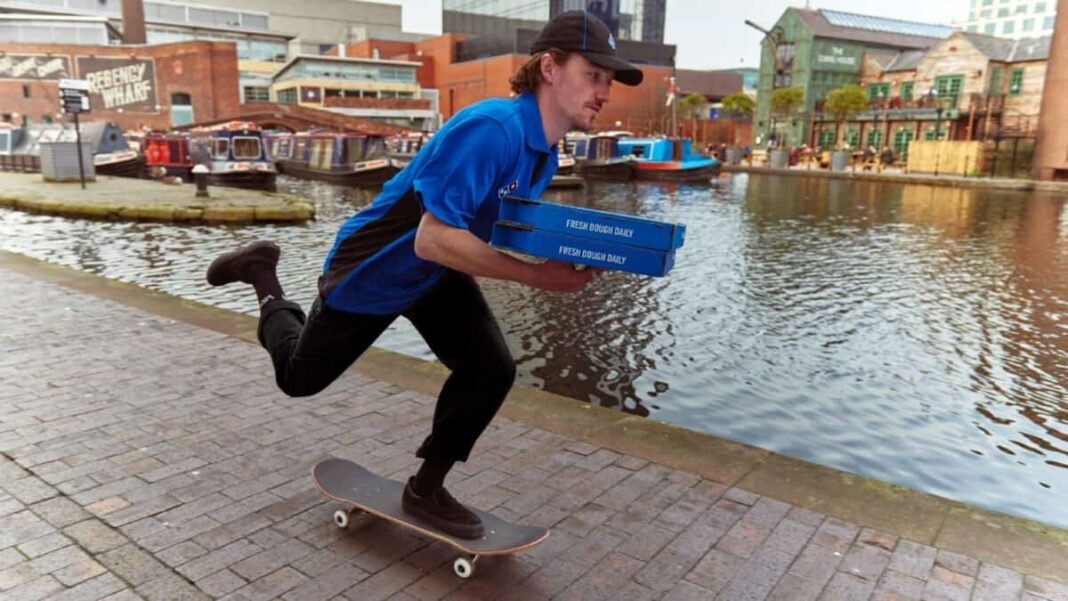 2 Passive Income Stocks Offering Dividend Yields Over 6% Dominos delivery man on skateboard holding pizza boxes