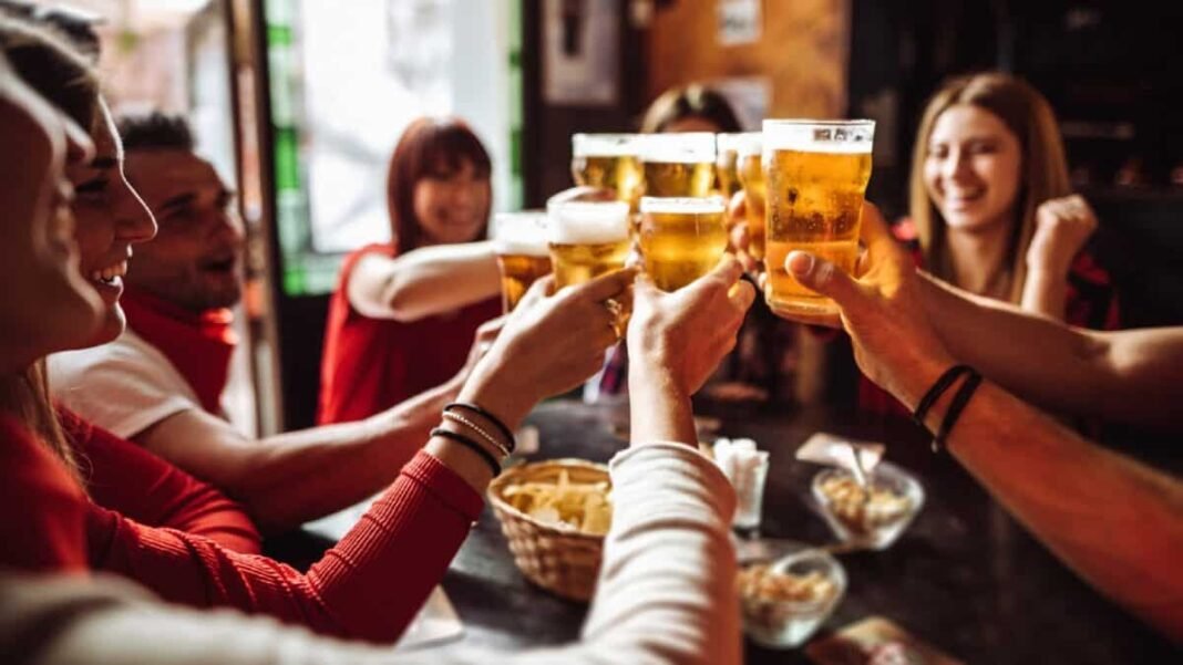 FTSE 100 shares: Is the once-in-a-decade chance to build wealth Group of young friends toasting each other with beers in a pub