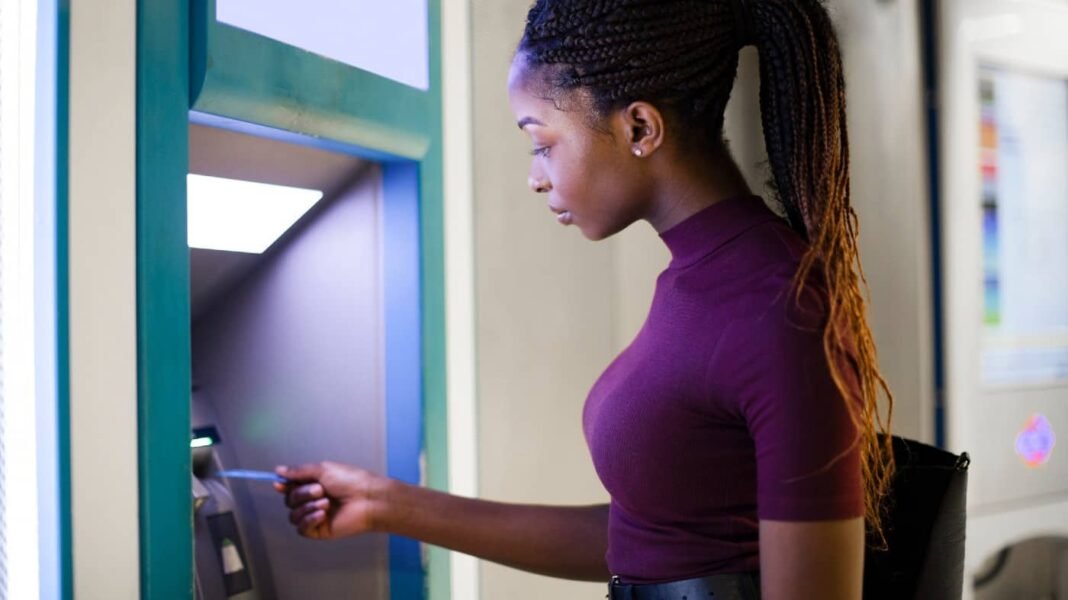 Hurrying to buy insanely cheap income stocks before it's too Young Black woman using a debit card at an ATM to withdraw money