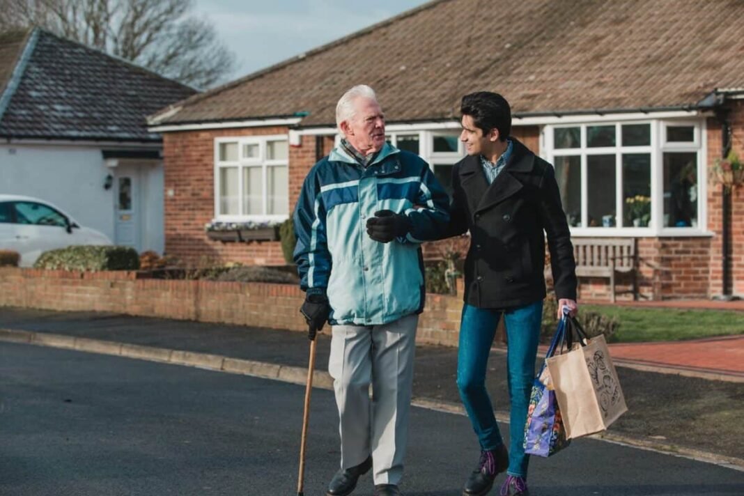 How much do you need in a SIPP to earn Teenage boy is walking back from the shop with his grandparent. He is carrying the shopping bag and they are linking arms.