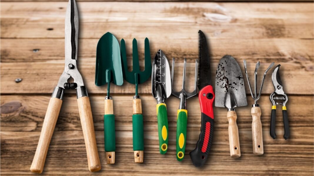 A close-up and overhead shot of a composition of gardening tools, placed on a wooden surface, showcasing garden tools before using