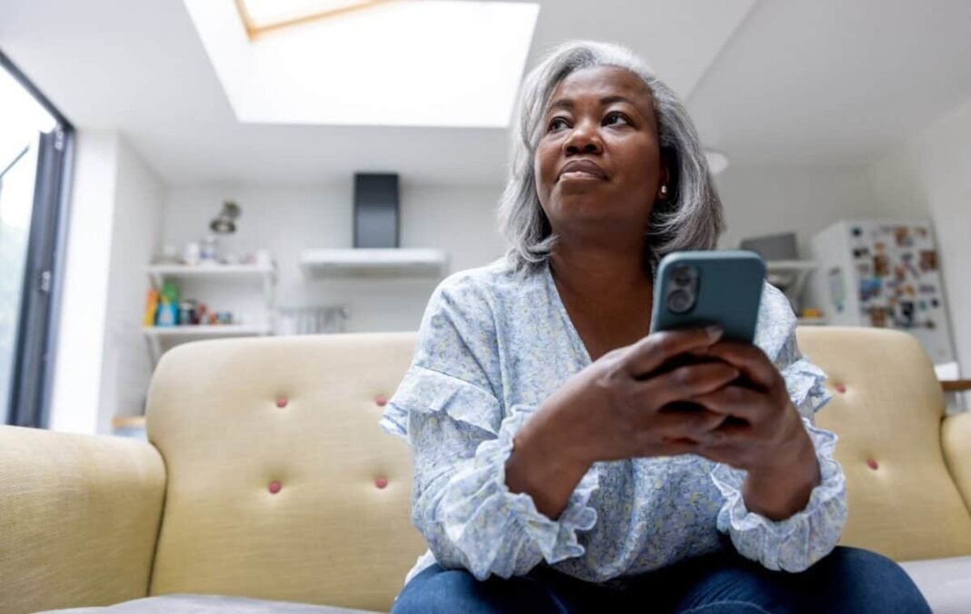 After a 91% drop, what will it take for Ocado's Mature black woman at home texting on her cell phone while sitting on the couch