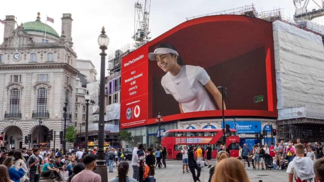 Vodafone's share price has increased by 71% in one year. Emma Raducanu for Vodafone billboard animation at Piccadilly Circus, London