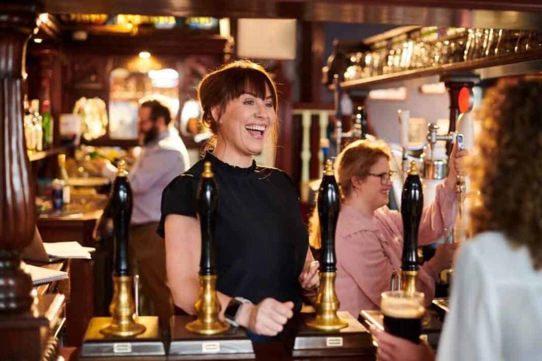 At over 11%, is Wetherspoon's share price too cheap to Landlady greets regular at real ale pub