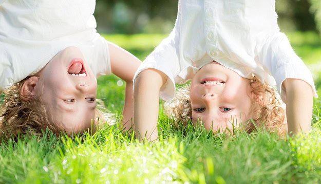 funny_quotes_for_children.jpg Two kids standing on their hands in the grass and laughing.