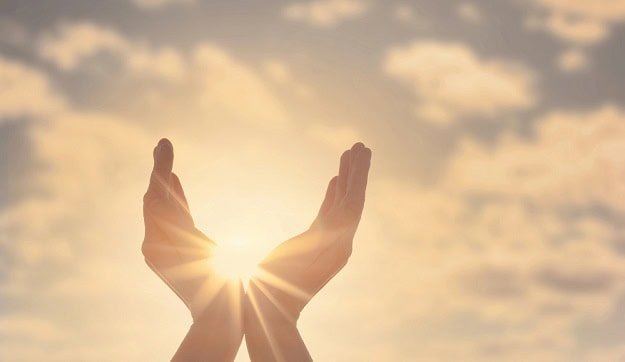 quotes_about_hope.jpg Two hands reaching towards the sky with the sun in the background.