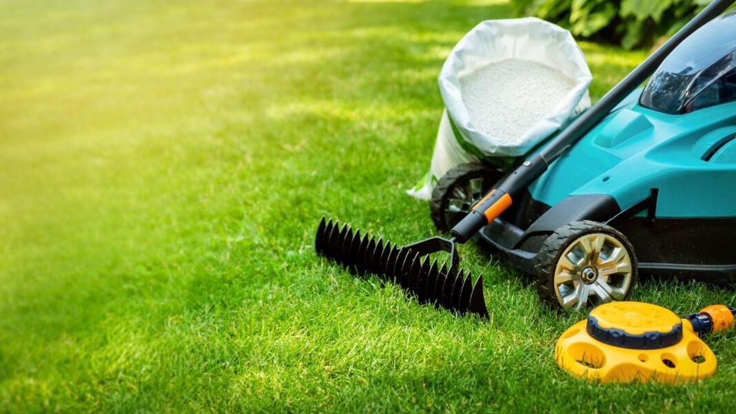 A close-up shot of several gardening tools and equipment, placed on clean turf, showcasing April lawn care