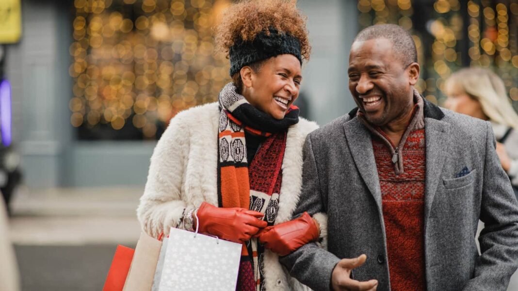 Can these eight FTSE 250 shares turn £20,000 into £297,276 Senior couple crossing the road on a city street. They are walking with shopping bags while Christmas shopping.