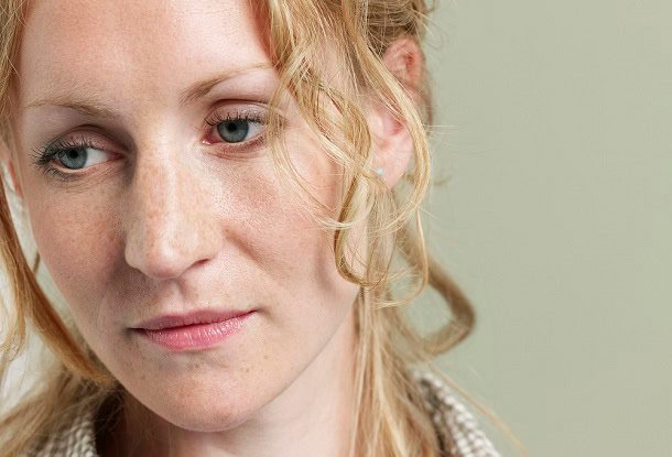 A woman looking thoughtful and a little bit sad.