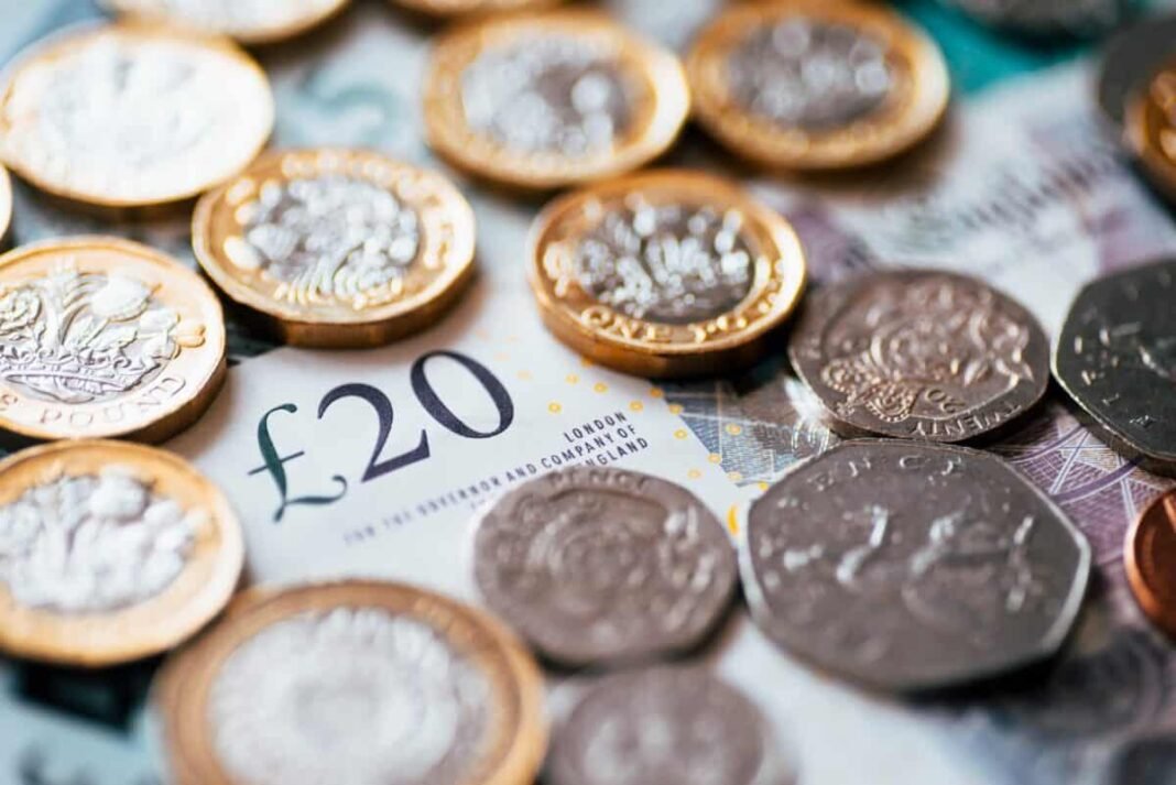 British coins and bank notes scattered on a surface