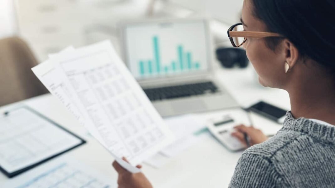 At less than £8, this UK high-growth fintech stock looks Businesswoman calculating finances in an office