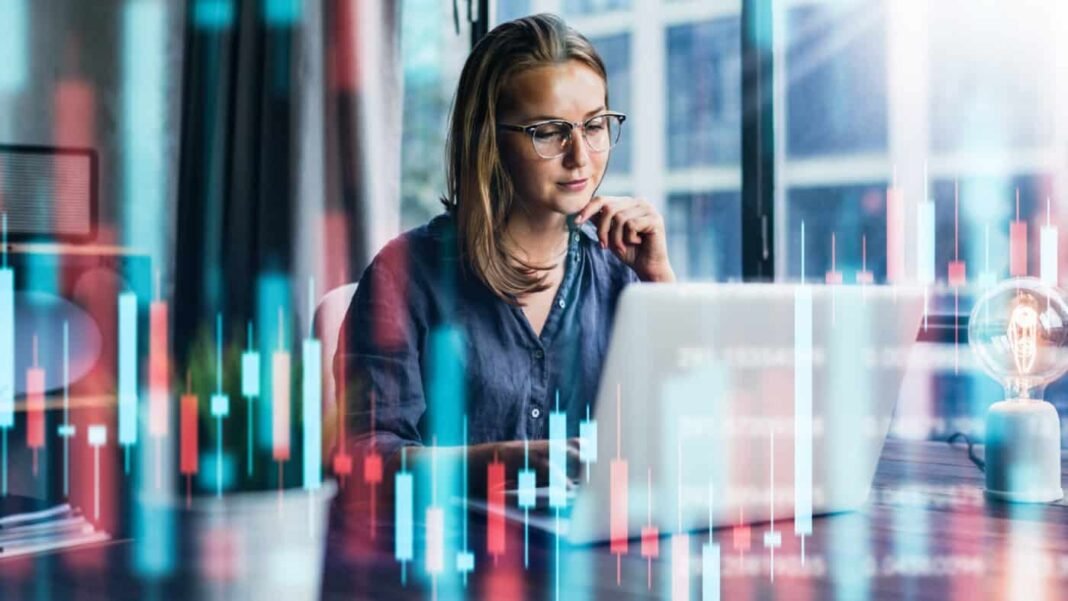 Nvidia's CEO believes the company could reach $1 trillion. Should Young woman working at modern office. Technical price graph and indicator, red and green candlestick chart and stock trading computer screen background.
