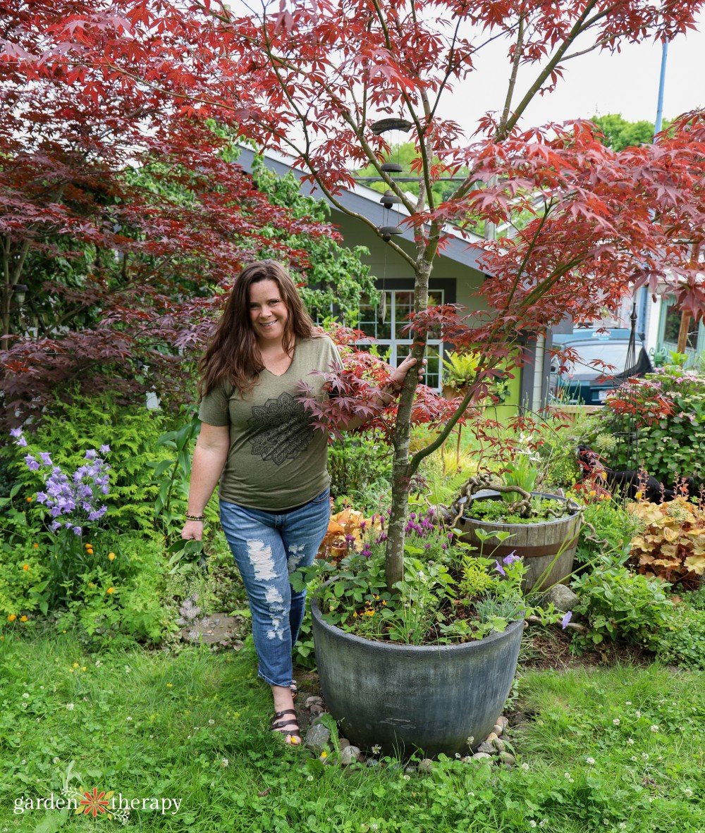 Stephanie-in-garden-with-Japanese-maple.jpg Stephanie smiling in garden with potted Japanese maple