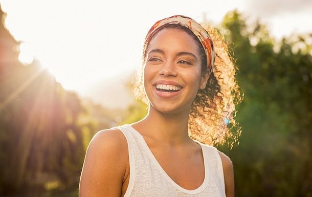 spread_positive_energy_2.jpg A smiling woman outside in the sunshine.